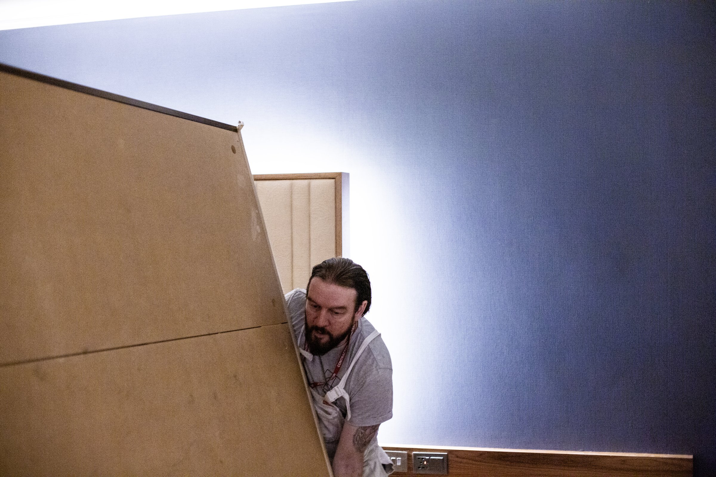 Sauce Interiors operative lifting a headboard panel during the refurbishment at Hilton Heathrow Terminal 5