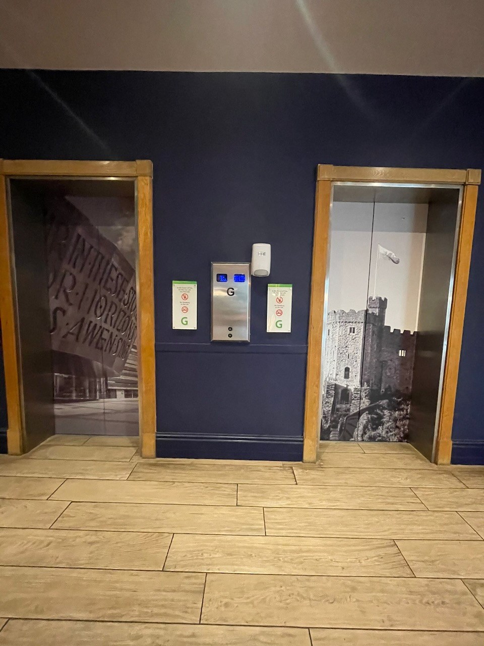 Hotel lift doors wrapped with black and white Cardiff scenes